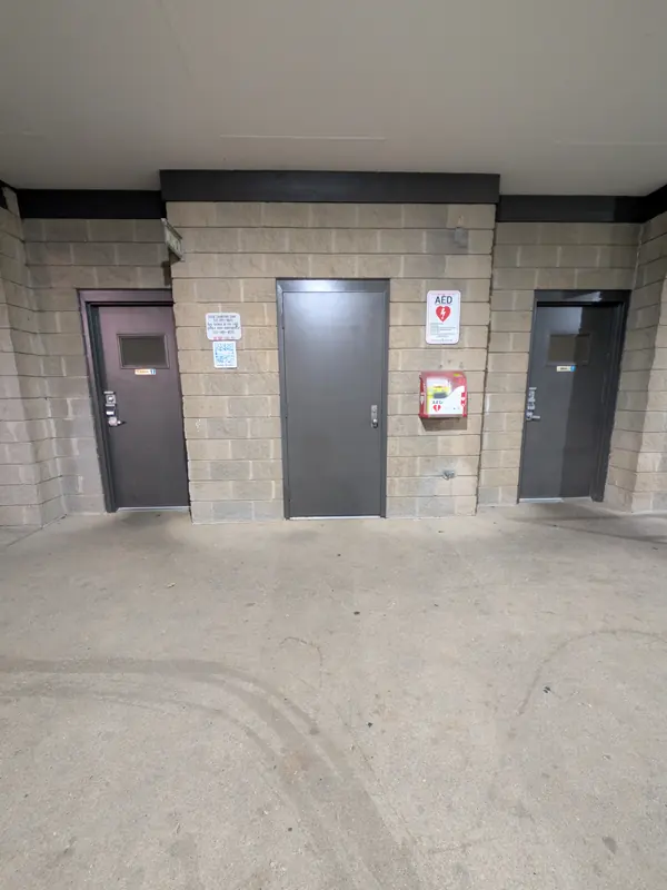 AED cabinet on the pavilion wall between the restroom doors