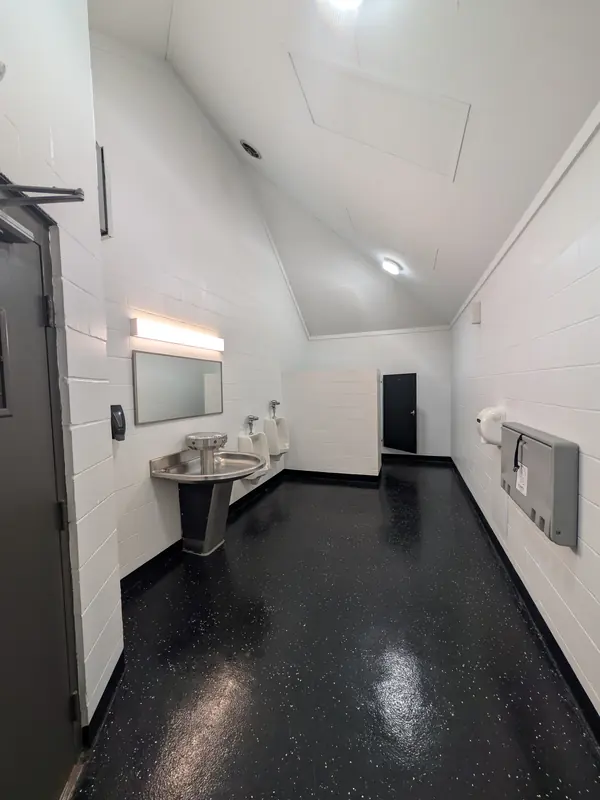 Inside a restroom at Blue Ash Sports Center, with a sink, urinals and a baby changing station